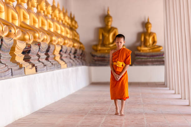 istock Young novice monk walking for meditation at Wat Phutthai Sawan temple 1297875708