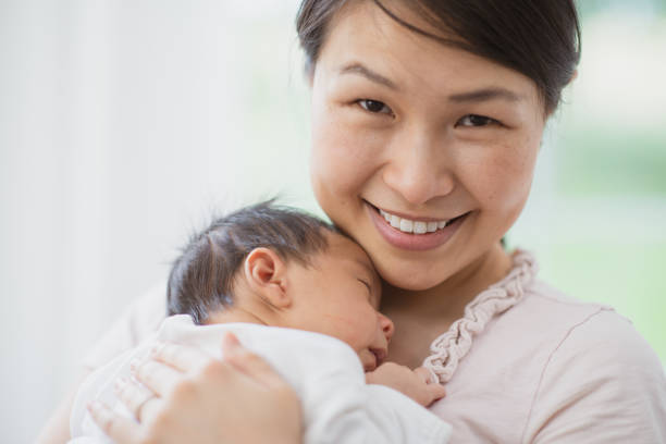 istock Mother snuggling newborn baby 1297877498