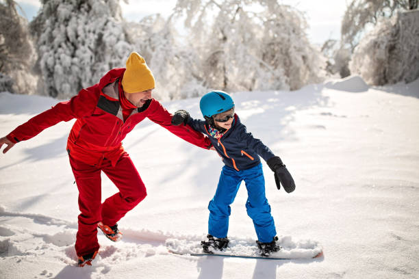 Yes you can Father teaching his son to board on snow back country skiing photos stock pictures, royalty-free photos & images