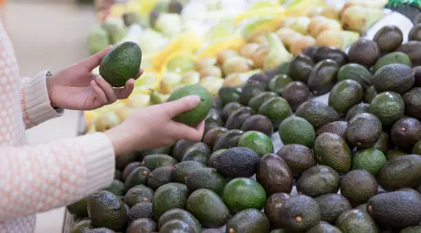 Asian women choose avocados in supermarkets