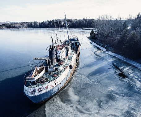 An abandoned ship that has broken from it's mooring and run aground on an island. Drone view.