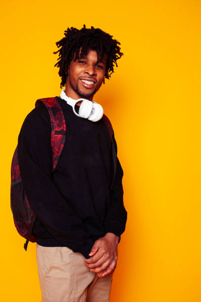 istock young handsome african american guy student posing cheerful and gesturing on yellow background, lifestyle people concept 1297896074