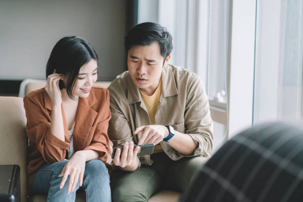 istock asian chinese couple using phone at apartment 1297897006