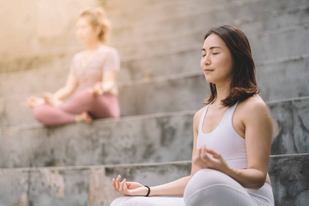 azjatyckie chińskie kobiety medytujące w parku - spirituality yoga zen like meditating zdjęcia i obrazy z banku zdjęć