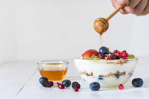 macedonia di frutta e yogurt - yogurt yogurt container strawberry spoon foto e immagini stock