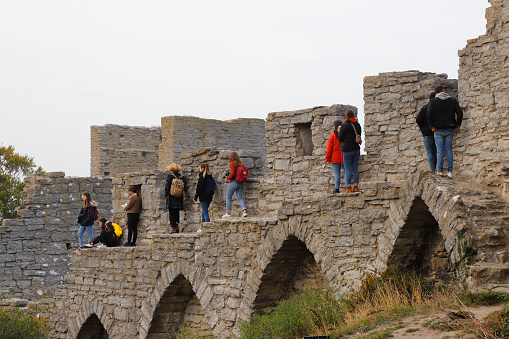 Visby, Sweden - October 2, 2020:  A group of tourists climbing on the medieval Visby city wall.