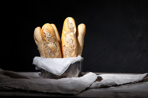 Fresh bread and buns on black background. Traditional bakery concept. 