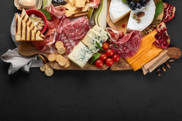 Appetizers table. Appetizers table. Cheese, fuits and meat board on dark  background. Top view, copy space"n charcuterie stock pictures, royalty-free photos & images