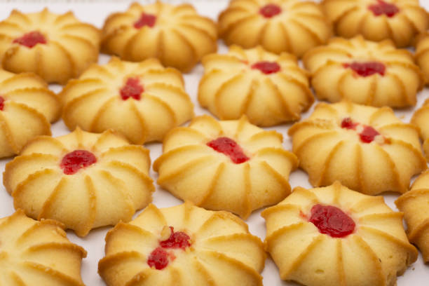 istock Shortbread cookies with jam in the middle on white plate against brown background . 1297905896