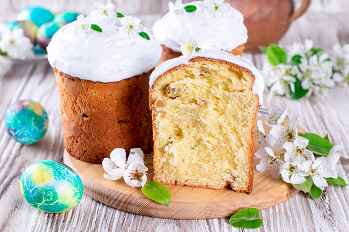 Easter composition with traditional Russian Easter bread kulich, Easter eggs and flowers on table