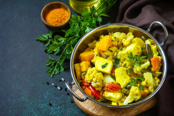 istock Sabji, Stewed pumpkin with soft cheese and vegetables on a dark stone table. Traditional Indian food. Copy space. 1297908889