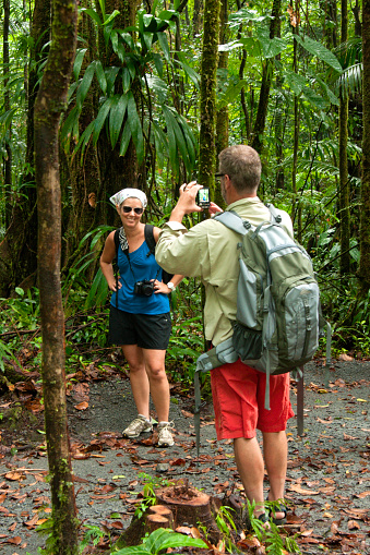 Man photograghing his hiking partner in the rainforest on the trail to Emerald Pool, UNESCO site, Dominica, West French Indies, Caribbean, Central America