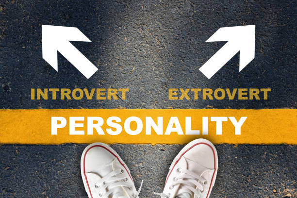 Personality written on yellow line with introvert and extrovert with white arrow on asphalt road stock photo