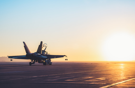 Jet fighter en una cubierta de portaaviones contra el hermoso cielo de la puesta del sol. photo