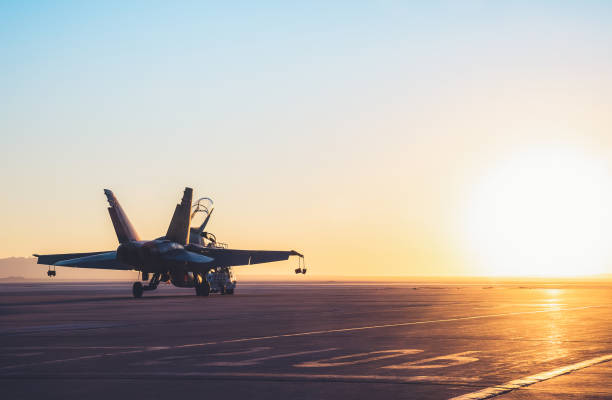 美しい夕日空に対する空母甲板上のジェット戦闘機. - military air vehicle ストックフォトと画像