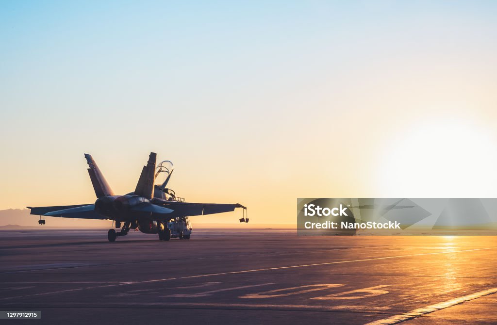Jet fighter on an aircraft carrier deck against beautiful sunset sky . Jet fighter on an aircraft carrier deck against beautiful sunset sky . Elements of this image furnished by NASA Military Stock Photo