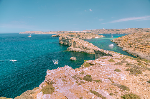 Comino island rocky coast and Mediterranean sea in a cloudless summer day.