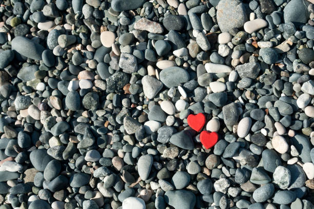 dwa czerwone serca wśród szarych kamieni - beach love heart shape two objects zdjęcia i obrazy z banku zdjęć