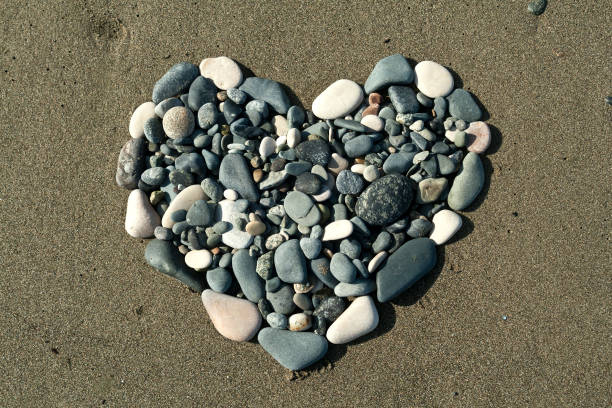 istock Beach stone heart on the sand 1297916786