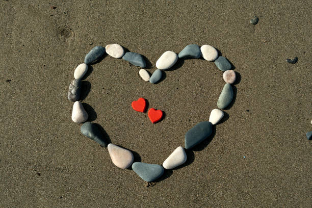 istock Heart from beach stones on the sand 1297916791