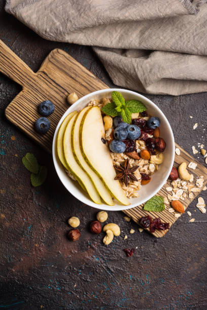 istock Oatmeal with fresh sliced pear, blueberry, almonds, hazelnuts and cashews nuts. 1297922207