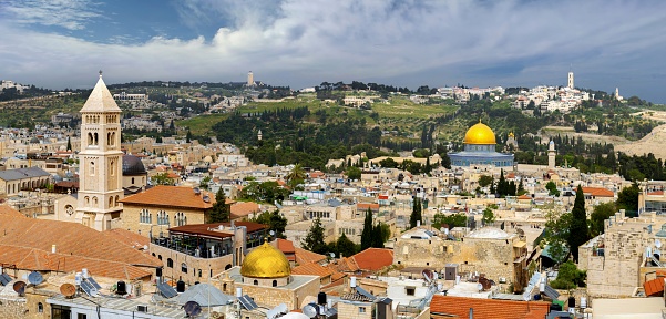 East Jerusalem, Palestine, May 2, 2019: Aerial view ov the Jerusalem Old City. On the left is the bell tower of the Lutheran Church of the Redeemer. Right is the golden cupola of the Dome of the Rock on the Temple Mount.