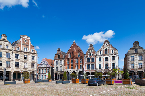 Arras, France - June 22 2020: Flamboyant Gothic buildings with Flemish gables and arcades along the Grand-Place in the city center.