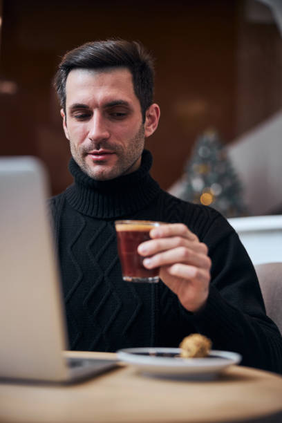 istock Cheerful handsome man with laptop drinking coffee 1297931842