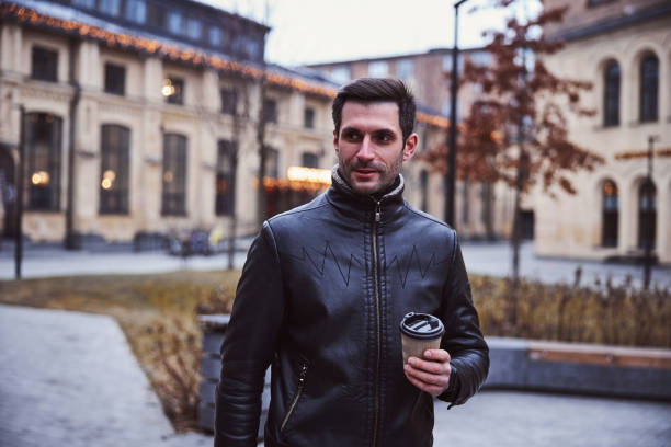istock Cheerful handsome man drinking coffee in street 1297931863