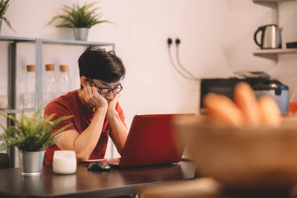 istock depressed asian chinese man looking at laptop screen at home 1297932258