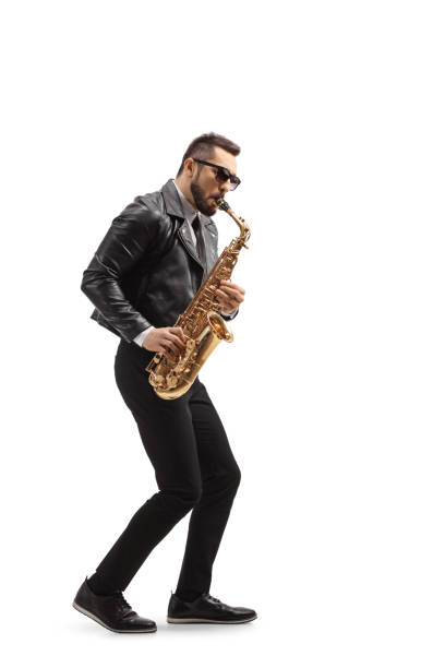 profilaufnahme in voller länge eines mannes in lederjacke, der ein saxophon spielt - saxophonist stock-fotos und bilder