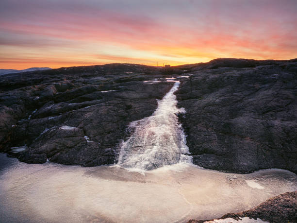 Frozen stream from a cliff. Atmospheric minimalist Arctic landscape.