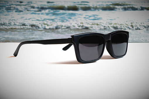 Illustrations that convey the meaning of good summer travel with images of sunglasses and beach with strong wave.