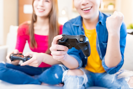 Cheerful teenage girls giving each other high five after winning videogame
