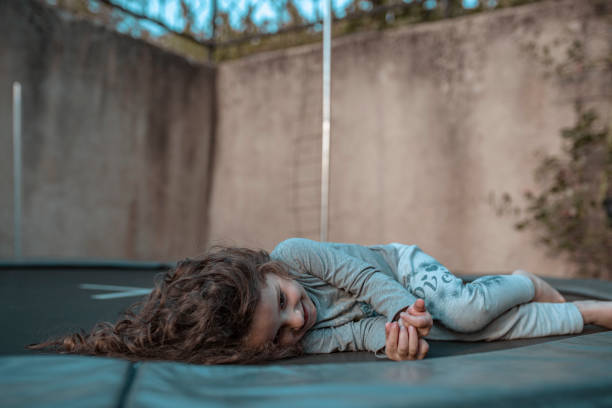 istock Little girl lying down on trampoline 1297945909