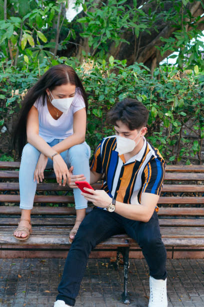 istock Couple with protective mask in the park 1297946215