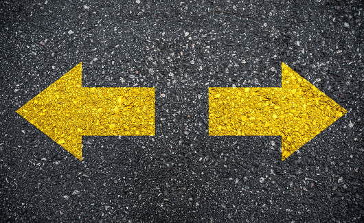 Top view of two white arrows in the asphalt of a road. Concept of guidance, lead and moving forward