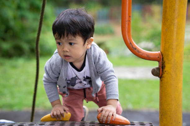 Adorable asian boy playing happily at the playground stock photo