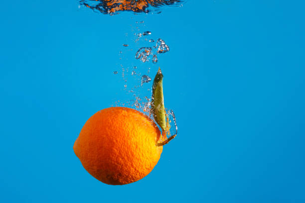 istock Orange falls into the water with a splash 1297950397