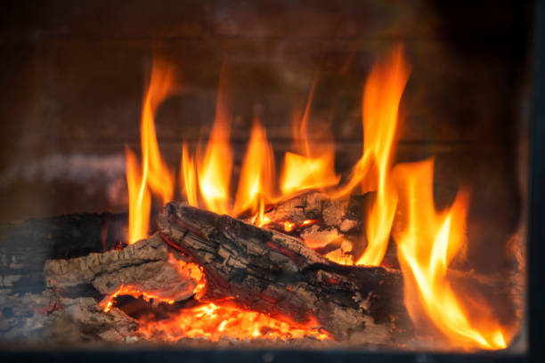 istock bright flaming fire flame in an extinct stone fireplace, through the glass, horizontal 1297950847
