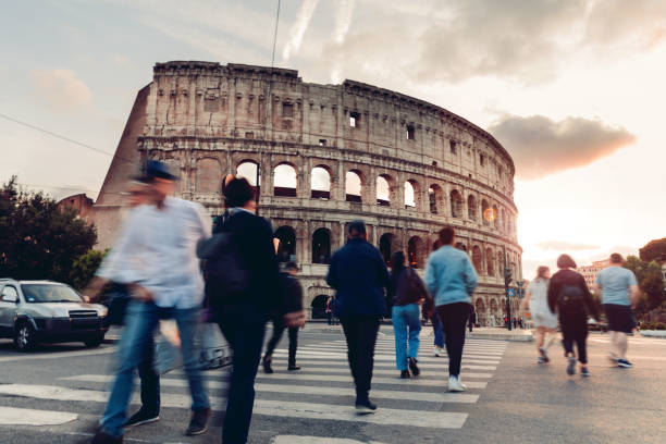 persone che attraversano la strada nel centro di roma davanti al colosseo - italy coliseum rome italian culture foto e immagini stock