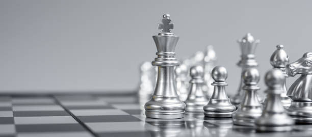 istock Silver Chess figure team (King, Queen, Bishop, Knight, Rook and Pawn) on Chessboard against opponent during battle. Strategy, Success, management, business planning, tactic, politic and leader concept 1297953446