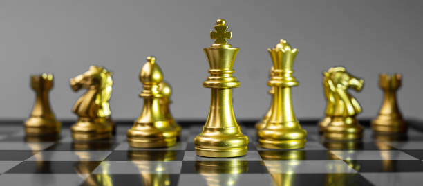 istock Gold Chess figure team (King, Queen, Bishop, Knight, Rook and Pawn) on Chessboard against opponent during battle. Strategy, Success, management, business planning, tactic, politic and leader concept 1297954318
