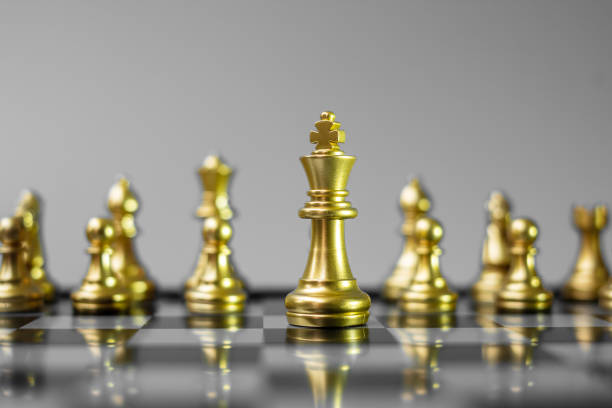 istock Gold Chess figure team (King, Queen, Bishop, Knight, Rook and Pawn) on Chessboard against opponent during battle. Strategy, Success, management, business planning, tactic, politic and leader concept 1297954497