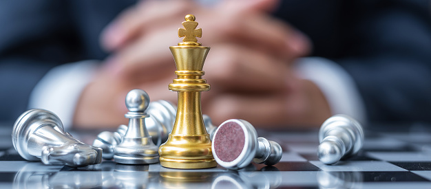 gold Chess King figure stand out from crowd of enermy or opponent during chessboard competition. Strategy, Success, management, business planning, interruption, win and leadership concept
