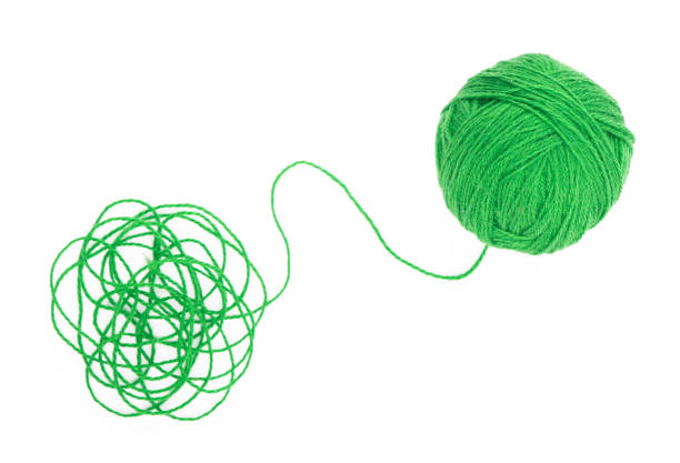Ball of yarn on the white background The idea is a tangled thread. Green ball of yarn on white background skein stock pictures, royalty-free photos & images