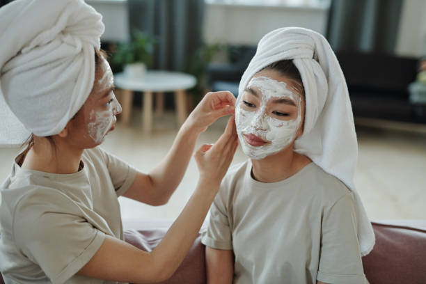 istock Girl helping her twin sister put towel on head while both relaxing after bath 1297961692
