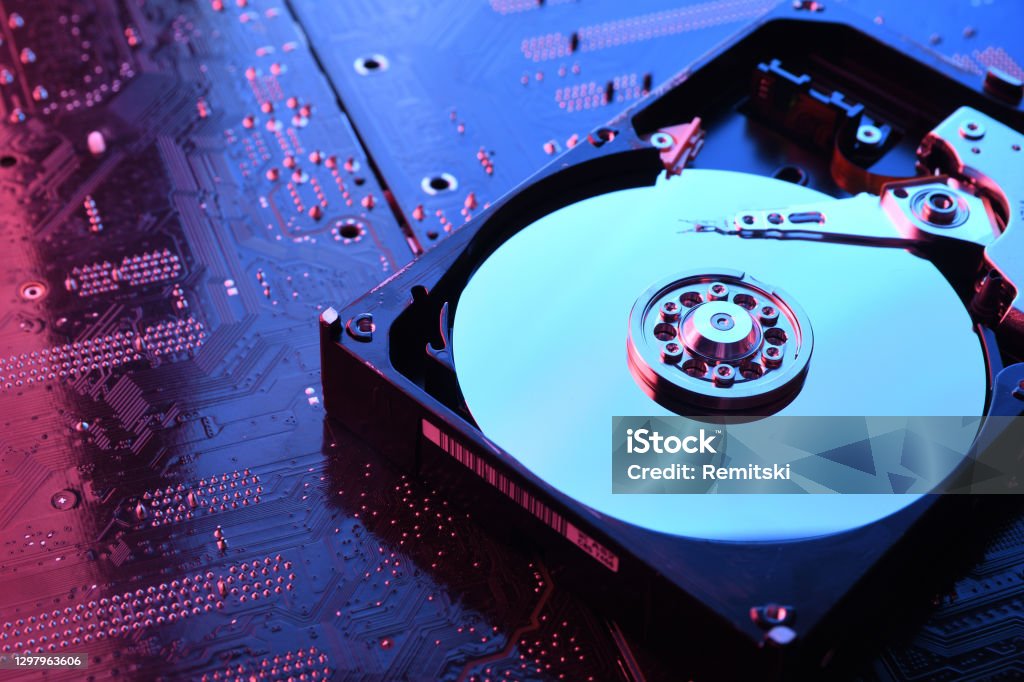 Computer Hard disk drives HDD , SSD on circuit board ,motherboard background. Close-up. With red-blue lighting Computer Hard disk drives HDD , SSD on circuit board ,motherboard background. Close-up. With red-blue lighting. Hard Drive Stock Photo