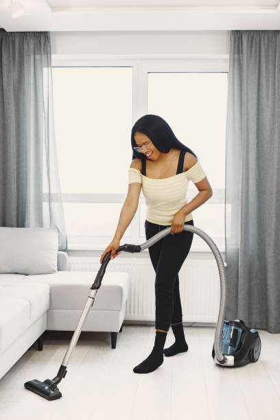 istock African american woman using vacuum cleaner at home 1297965587