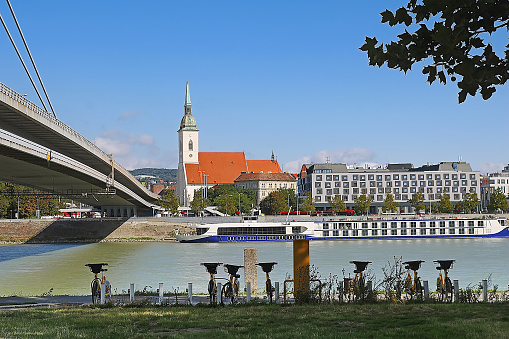 Bicycles for rent on the foreground, bridge and Saint Martins cathedral on the background, the river Danube, historical centerof Bratislava city, Slovakia